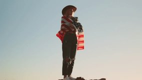 Patriotic woman wearing cowboy hat confidently waving american flag on scenic hilltop during sunset, embodying national pride and freedom.Usa celebrate 4th july. Independence day concept - Powered by Shutterstock - Get 15% off with code: PIKWIZARD15