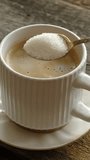 Vertical video. Drinking coffee. Hand stirring sugar in mug of espresso coffee.  - Powered by Shutterstock - Get 15% off with code: PIKWIZARD15