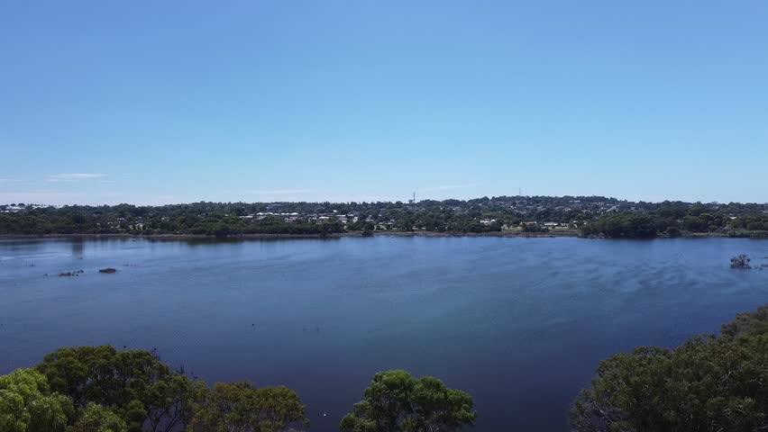 Aerial tilt down view over Joondalup Lake shoreline, Perth Australia