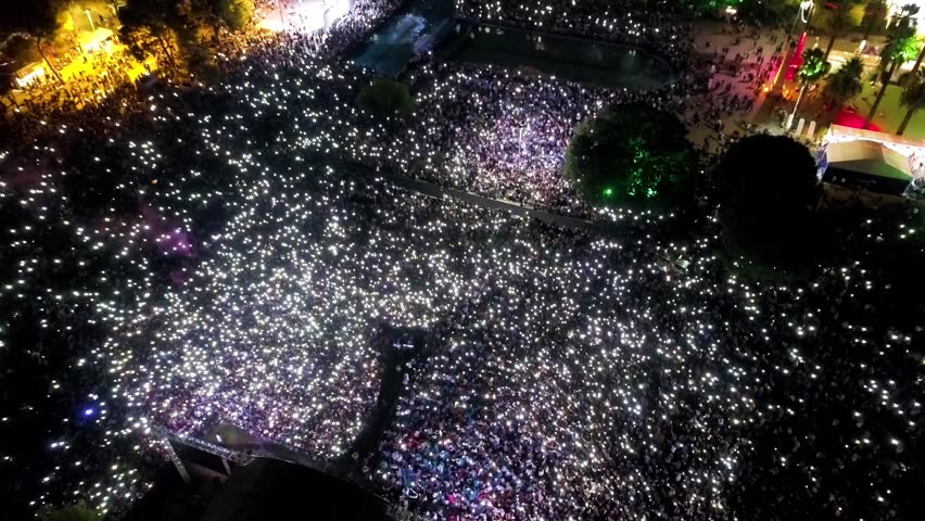 People at the concert - aerial shot taken by drone of thousands of people making lights with their phones at the concert