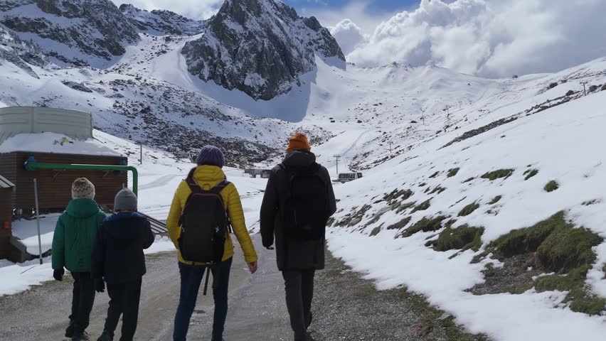 Mountain hikers traversing snow-covered trail, surrounded by winter landscape, experiencing serene wilderness and scenic alpine environment