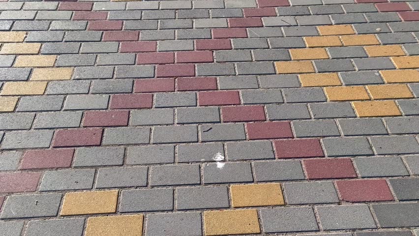 A brick walkway with a cross on it.