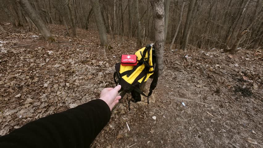 A vibrant yellow backpack with a first aid kit against a serene forest backdrop. Its ideal for outdoor enthusiasts and highlights the importance of safety for all adventurers in the wild