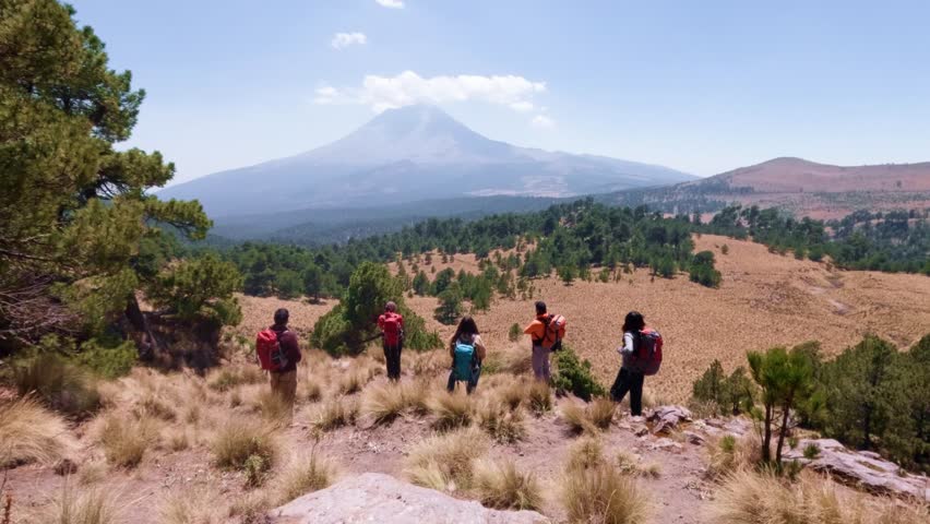 Group of hikers contemplating iztaccíhuatl volcano in iztaccihuatl-popocatepetl national park, mexico