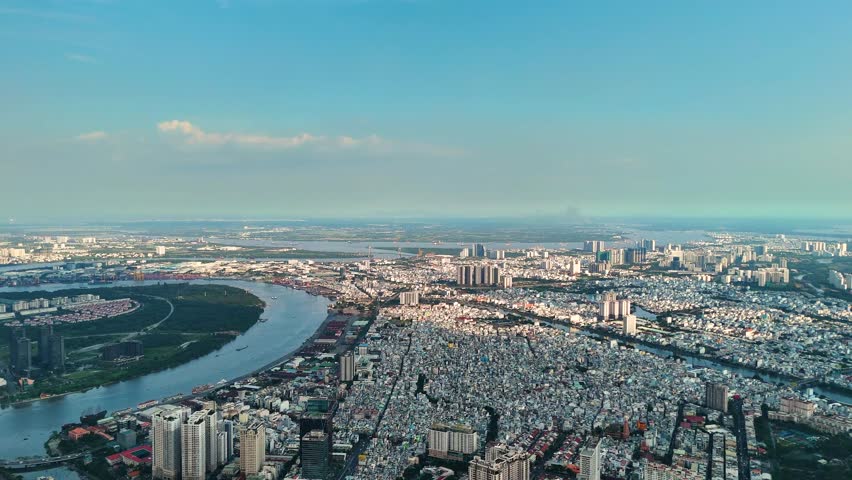 Aerial: sunset, Saigon River and cityscape in Ho Chi Minh City, Vietnam, pan drone shot