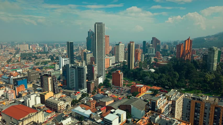 Panoramic dolly in flyover of the city of Bogota, Colombia on a sunny day with the Colpatria tower and the other skyscrapers of the financial center.