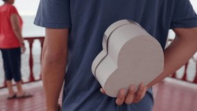 Affectionate grandson surprising his grandmother with a heart shaped gift, embracing and sharing a tender moment by the sea - Powered by Shutterstock - Get 15% off with code: PIKWIZARD15