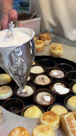This is a vertical video of a popular street food from a family owned business making mochi cakes to sell to customers in Chongqing, China