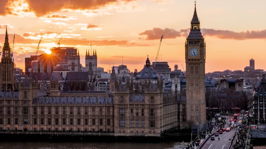 Close-up sunset to night time lapse view of the Big Ben clocktower in London with street and people traffic, England