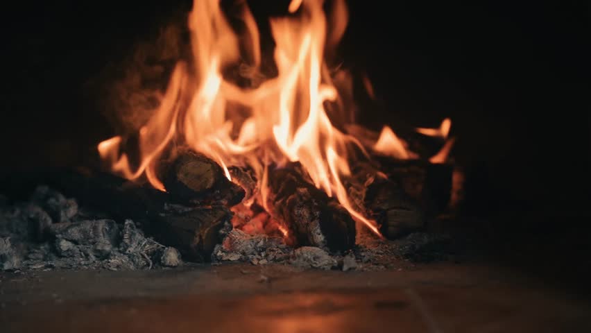 A knife lies in glowing embers of a fire, evoking warmth, survival, and resilience