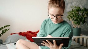 Teenage girl sitting on bed with tablet and stylus, thoughtfully creating digital art. Creative environment, cozy atmosphere and focus on learning from home and artistic self-expression. - Powered by Shutterstock - Get 15% off with code: PIKWIZARD15