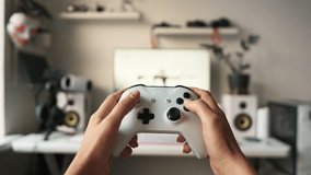 Close-up of hands holding white gaming controller during console gameplay. Modern gaming setup and digital entertainment concept. Playing video game, person holding controller and focusing on winning. - Powered by Shutterstock - Get 15% off with code: PIKWIZARD15