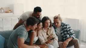 A group of diverse friends gathers in a cozy living room, sharing moments of laughter and surprise as they watch something on a smartphone. Their expressions reflect joy and engagement. - Powered by Shutterstock - Get 15% off with code: PIKWIZARD15