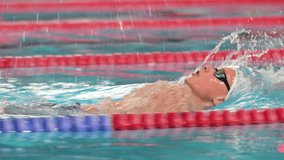 Swimmer boy swims backstroke swimming style in the pool.  - Powered by Shutterstock - Get 15% off with code: PIKWIZARD15