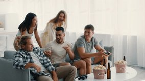 A group of diverse friends gathers in a cozy living room, laughing and cheering as they play video games. Snacks and drinks are scattered as they celebrate their time together. - Powered by Shutterstock - Get 15% off with code: PIKWIZARD15