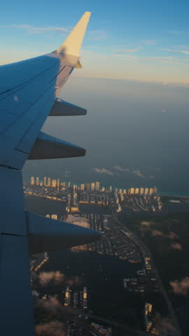 Vertical Screen: The breathtaking view from an airplane window during flight beautifully captures the sky and clouds at sunset. The airplane is gracefully taking off into the evening sky