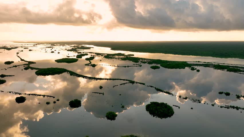 Freshwater natural lake Bacalar tropical rainforest, ecological corridor, Sunset light reflecting cloud on shallow turquoise lake water surface, Aerial closeup
