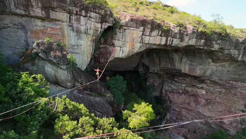 Aerial zoom-out of highliner walking highline near Gruta do Lapão cave, Chapada Diamantina, Bahia