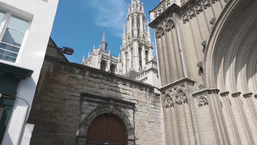 Towering Cathedral of Our Lady in Antwerp, Belgium, viewed from a charming narrow alley