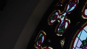 Panning shot of stained glass window with roses as the main decoration - Powered by Shutterstock - Get 15% off with code: PIKWIZARD15