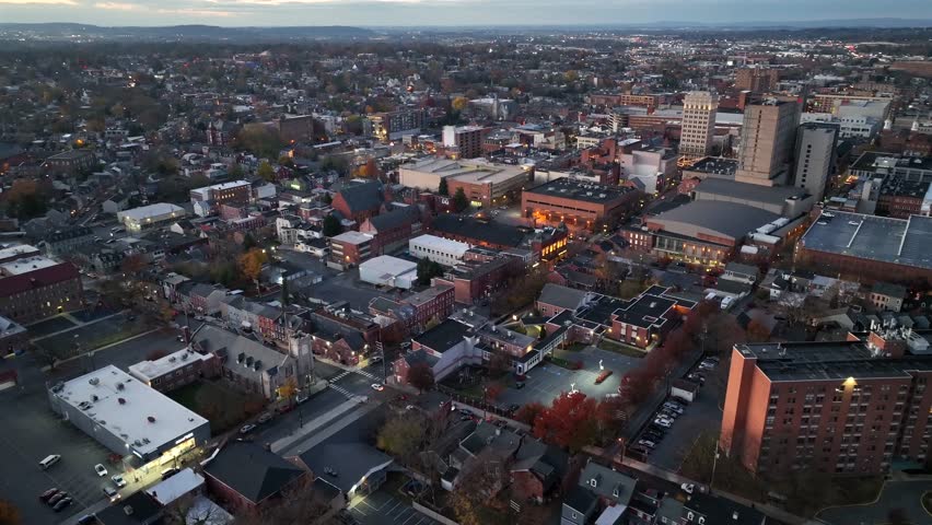 Aerial approaching shot of Main Street with driving cars at dusk. Historic houses and homes near downtown of american town. Wide shot. Clear weather in winter season.