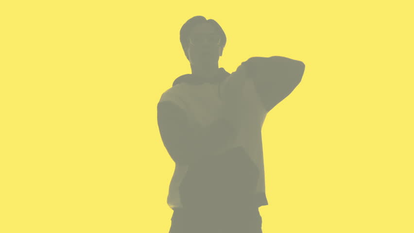 Hip hop dancer silhouette. Breakdance choreography. Blur faded double exposure outline of energetic guy performing freestyle movements isolated on yellow copy space background.