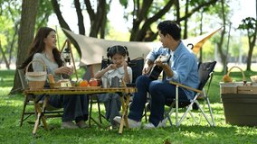 Asian family enjoying a picnic in the park on a sunny weekend. Smiling parents and kids bonding, relaxing, and spending joyful time together in nature. - Powered by Shutterstock - Get 15% off with code: PIKWIZARD15