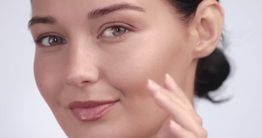 Caucasian woman smiles while touching her radiant skin, showcasing results from skincare treatment. Ideal for before-and-after visuals, cosmetic dermatology, and skincare testimonials.