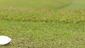A golfer's gloved hand carefully places a golf ball on a tee on the grass. - Powered by Shutterstock - Get 15% off with code: PIKWIZARD15