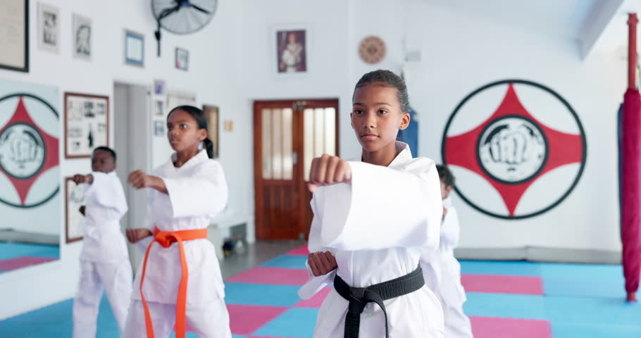 Group, karate and children exercise in dojo for fight, fitness and learning self defense in class for sports. Students, kids and practice martial arts for development, workout and punch for training