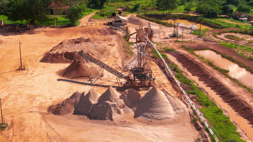 Drone aerial pan of sand dredger machinery tools for extraction removing sediment operations sand piles industry in countryside farmland property dam Brazil South America.