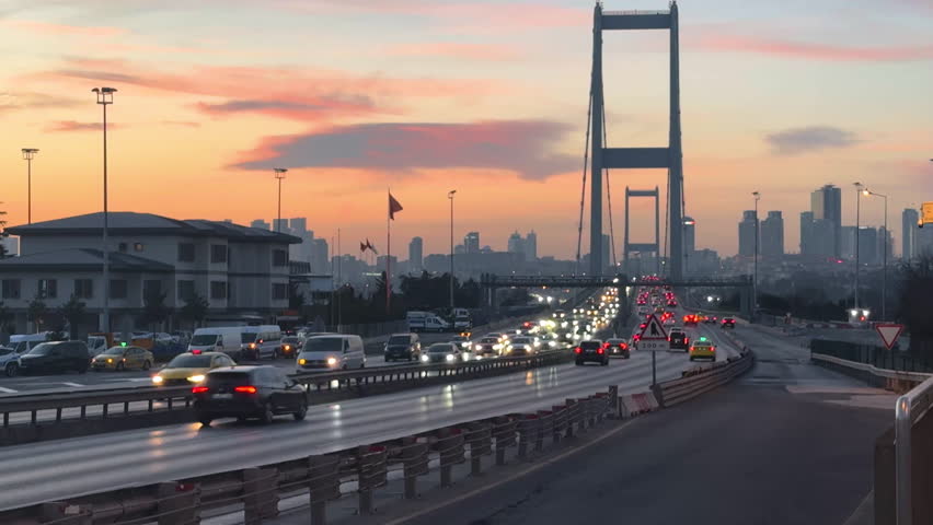 Large bridge at sunset. Beautiful cityscape background. Cars drive roadway. View of evening city. Urban transportation. Town infrastructure. Modern road way. Transport highway.