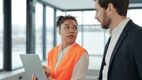 Professional architect and construction engineer discuss a project in a modern office space. Multinational team of engineers, African American woman and Caucasian man working a real estate investment. - Powered by Shutterstock - Get 15% off with code: PIKWIZARD15