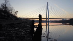 Drone slides low to reveal Northern Spire Bridge in Sunderland during predawn twilight, capturing its reflection on the River Wear at sunrise. - Powered by Shutterstock - Get 15% off with code: PIKWIZARD15
