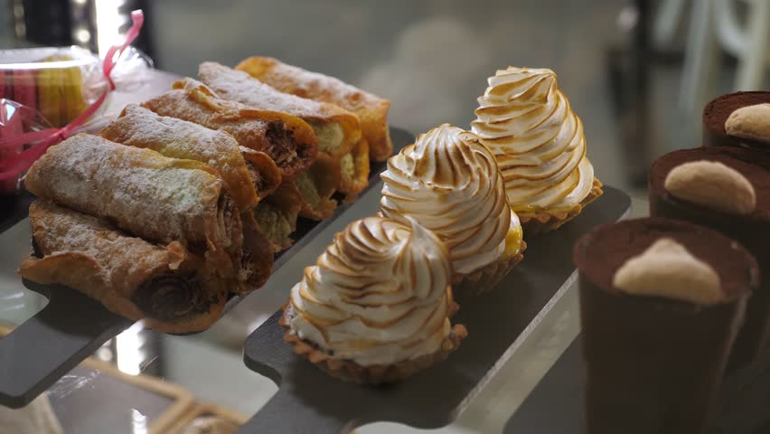 Various cakes on the counter in a modern cafe or pastry shop. Delicious fresh cakes in the pastry shop behind the glass.
