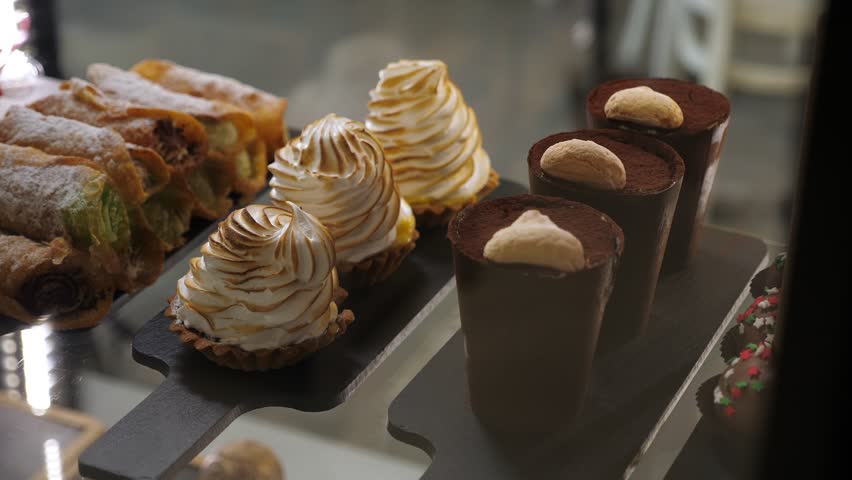 Various cakes on the counter in a modern cafe or pastry shop. Delicious fresh cakes in the pastry shop behind the glass.