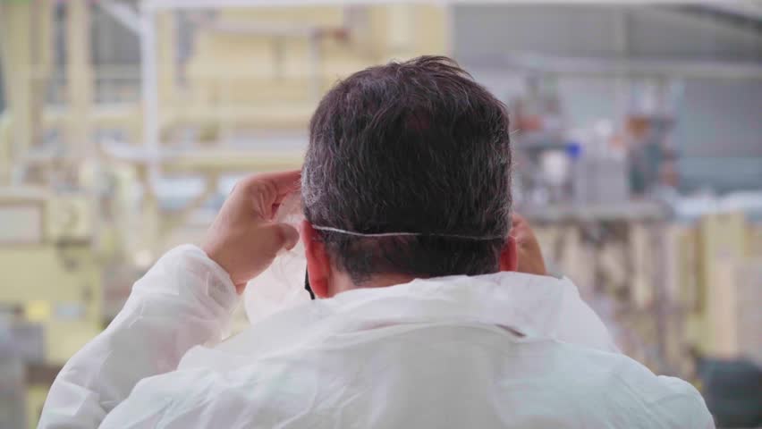 Worker covering head with a safety net snood to keep hygiene in a food industry factory