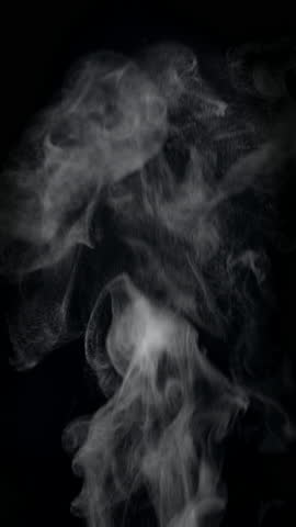 White natural rising steam from food or hot drink isolated on a black background. Сould be used in any projects with hot food. Slow motion vertical template.