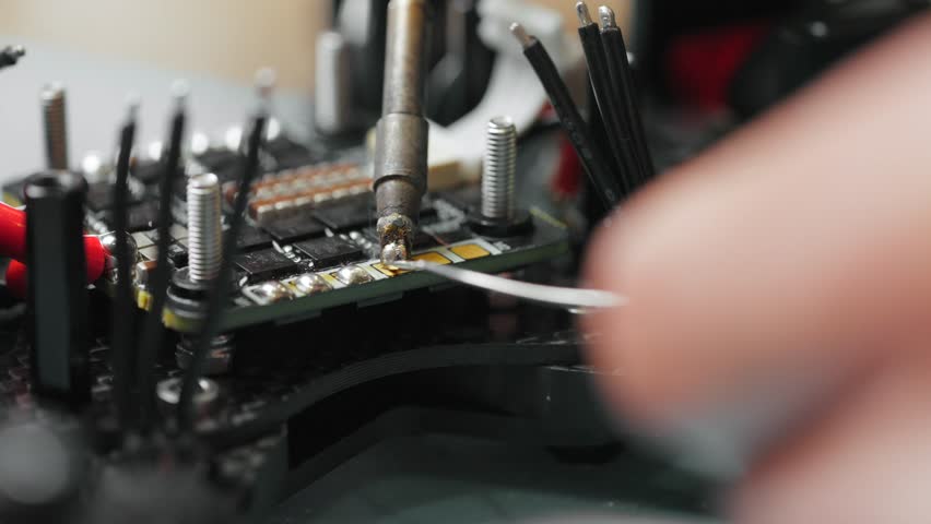 Technician soldering components onto circuit board of disassembled fpv drone - Powered by Shutterstock - Get 15% off with code: PIKWIZARD15