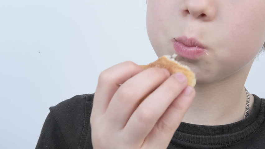 child, Young 10-year-old boy eating fresh croissant, chewing sweets pastry, kid has good appetite, happy childhood, balanced diet, sweet life, unhealthy food