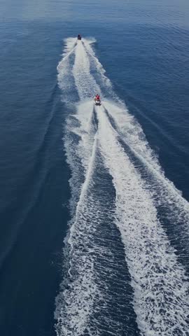 Epic footage of two water scooters racing at crystal clear water of Indian Ocean. Young couple enjoying summer vacation near Thulusdhoo island.Maldives.Vertical video
