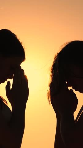 Christian prayer nature. Morning prayer of girls in outdoors. Freedom of religion. Young women praying at sunset, silhouette. Path of soul to God through prayer. Era of mercy kindness love. Girl relax