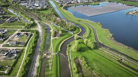 Aerial footage of floating solar farm on water, surrounded by canals and green spaces with a train crossing the landscape, residential areas and industrial zone. Sustainable infrastructure with urban. - Powered by Shutterstock - Get 15% off with code: PIKWIZARD15