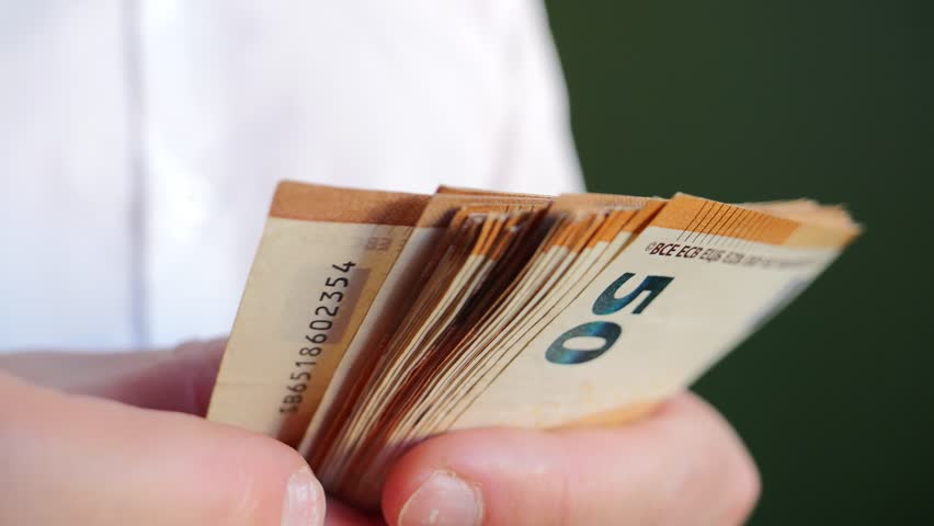 Money changing hands in a business transaction during a sunny afternoon in a bustling city environment