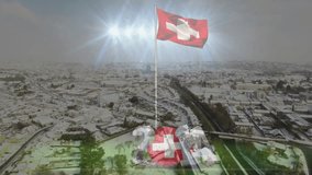 Snow-blanketing urban landscape showing Swiss flag flying on pole with sun glare and 2021 overlay. Winter, aerial, architecture, industrial, landscape, patriotic, festive - Powered by Shutterstock - Get 15% off with code: PIKWIZARD15
