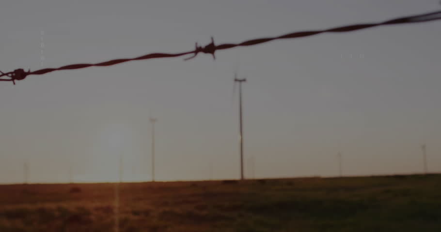 Wind turbine spinning over grassy plain at sunset, showing floating binary code and red symbols. Renewable, sustainability, technology, digital, energy, ecological, future