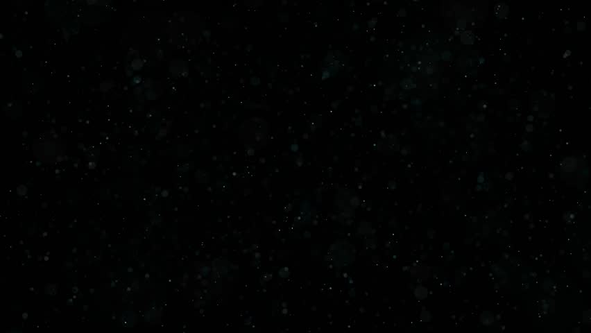 Beautiful shiny dust particles fly abstract black bokeh background. Glitter floating air. Magic glow sequins close up. Iridescent sparkles shimmer. Blurry spangles waving. Holiday Christmas decoration