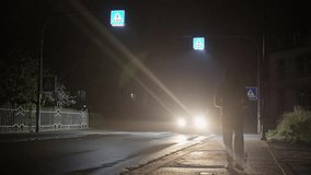 A lone man runs down the street at night. On a dim street filled with traffic at night, amidst shadows and headlights. Slow motion - Powered by Shutterstock - Get 15% off with code: PIKWIZARD15