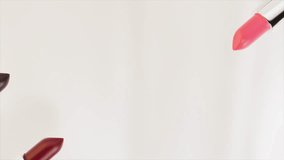 Lipstick collection rotating gently on white background, showcasing vibrant red and burgundy shades with elegant, visually dynamic presentation. 3D Illustration - Powered by Shutterstock - Get 15% off with code: PIKWIZARD15