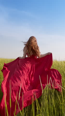 Slow Motion Redhead Woman In Flowing Red Silk Dress Running Barefoot Through Green Wheat Field Summer Wind Vertical Clip Natural Beauty Youthful Freedom Feminine Energy Cinematic Outdoor Fashion